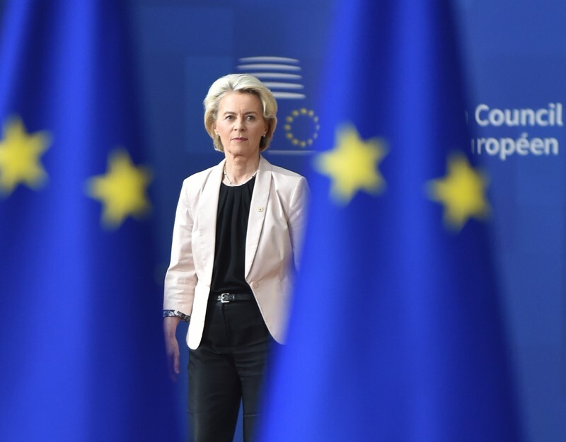 EU-Kommissionspräsidentin Ursula von der Leyen zwischen zwei EU-Fahnen