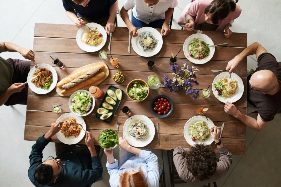 Mehrere Menschen sitzen an einem Tisch und essen