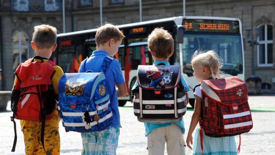 Kinder warten auf den Schulbus