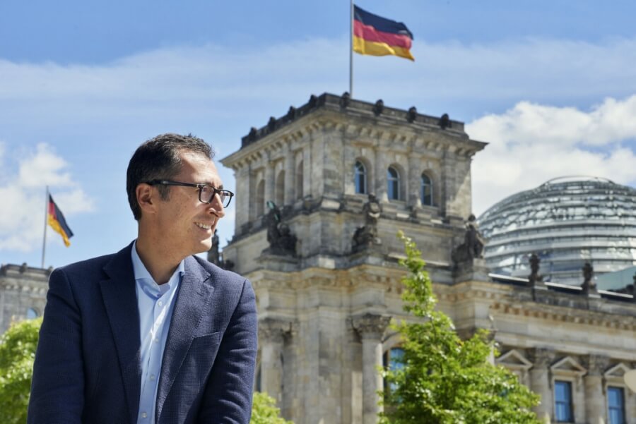 Cem Özdemir sitzt vor dem Gebäude des Deutschen Bundestages