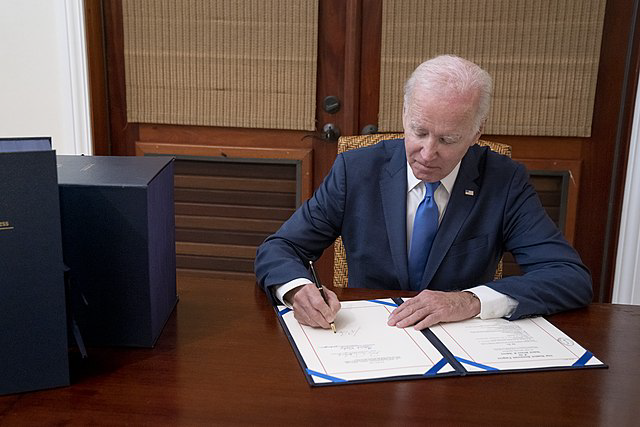 Der US-Präsident Joe Biden unterzeichnet eine Urkunde