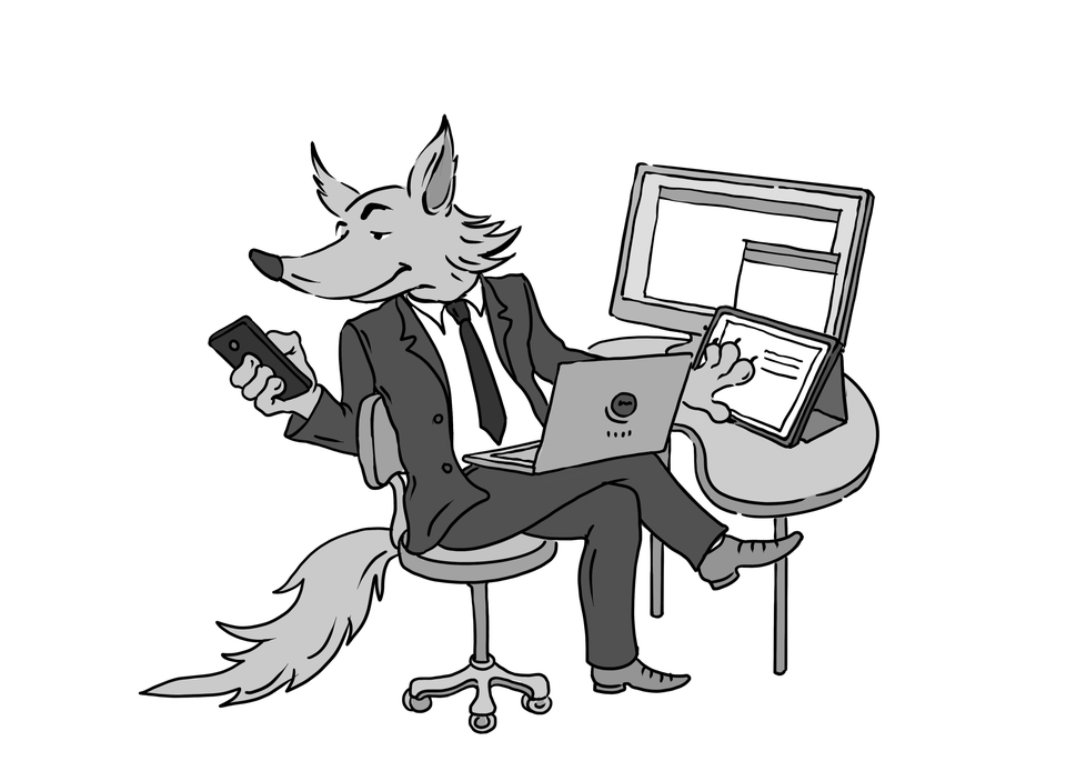 Der FUCHS sitzt am PC mit einem Laptop auf dem Schoß und dem Mobiltelefon in der Hand.