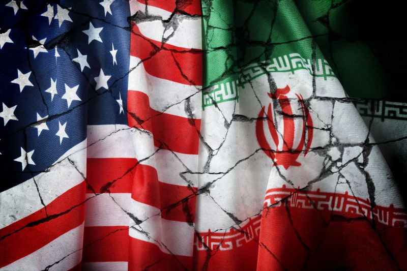 Die Fahnen von USA und Iran auf gebrochenem Grund