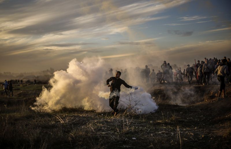 Palästinensischer Demonstrant wirft eine Tränengasgranate in Gaza Stadt