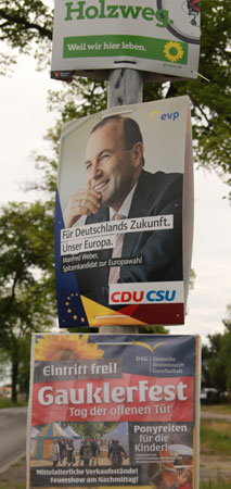 Wahlplakat der CDU über einem Plakat eines Gauklerfests