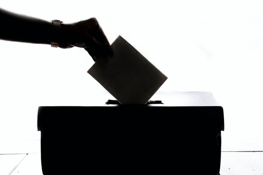 Ein Wahlzettel wird in eine Wahlurne geworfen