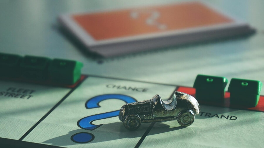 Rennauto-Figur auf einem Monopoly-Spielbrett