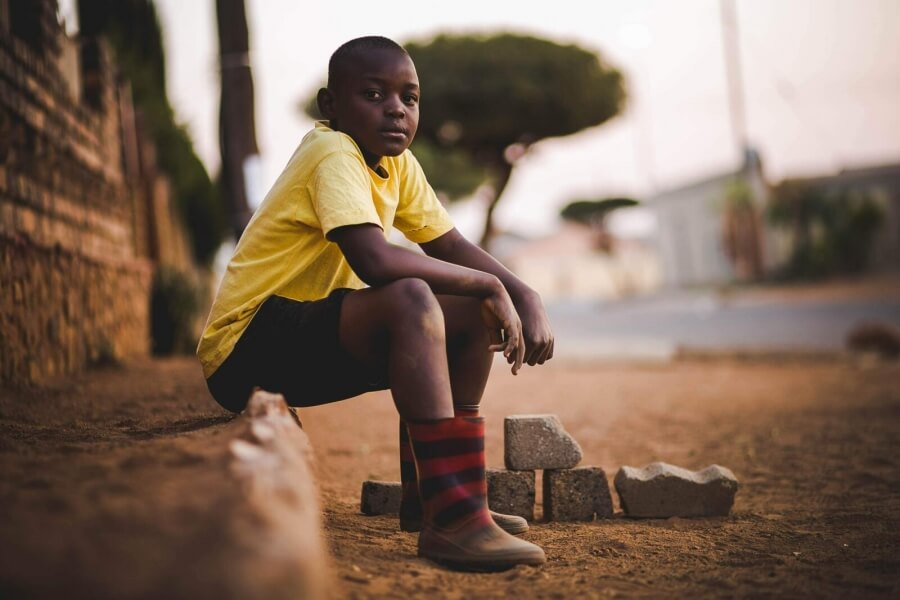 Ein Junge sitzt auf einer Straße in Afrika