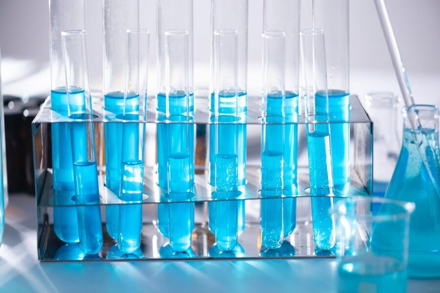 Sechs Reagenzgläser mit blauer Flüssigkeit in einem Labor