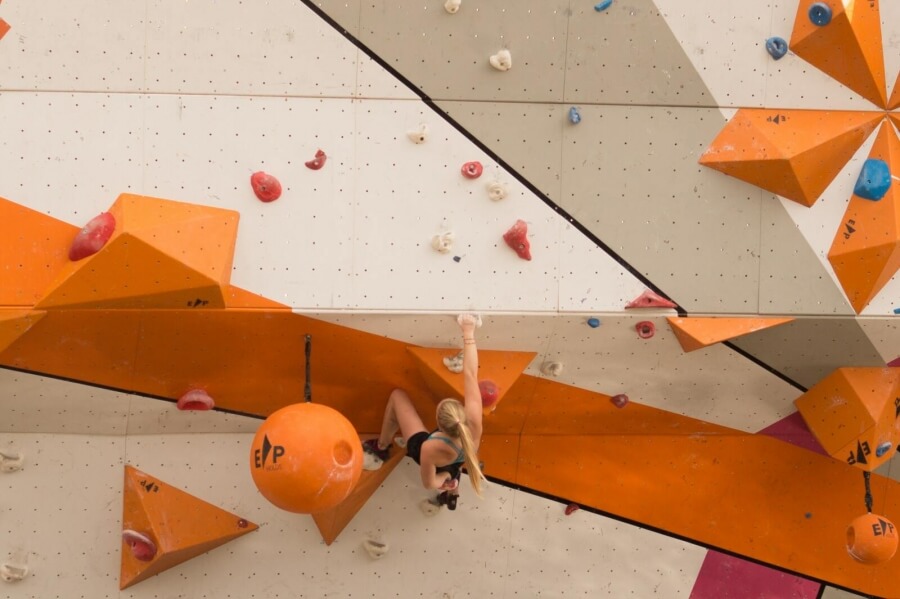 Eine Frau klettern in einer Boulder-Halle
