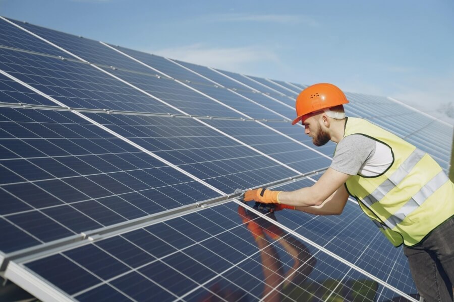 Ein Handwerker montiert ein Solarzellen-Panel