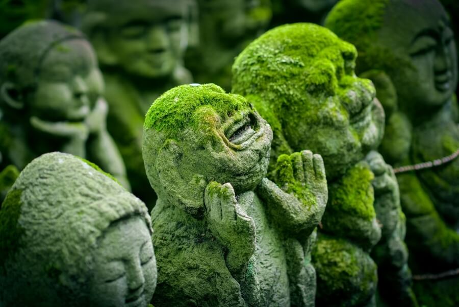 Mit Moos überwachsene japanische Statuen