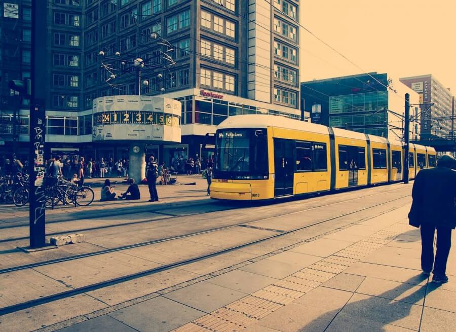 Eine Straßenbahn fährt auf dem Berliner Alexanderplatz an der Weltzeituhr vorbei