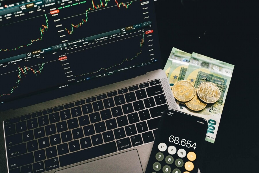 Bitcoin, Geldscheine, Laptop und Taschenrechner