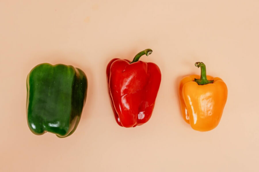 Drei Paprikas in den Farben grün, rot und gelb
