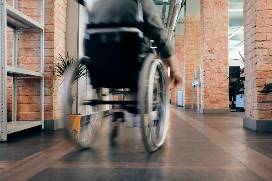 Eine Person im Rollstuhl fährt durch einen Raum