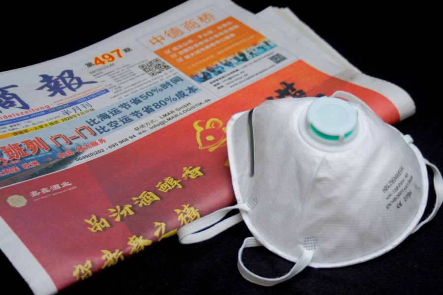 Atemschutzmaske auf chinesischer Zeitung