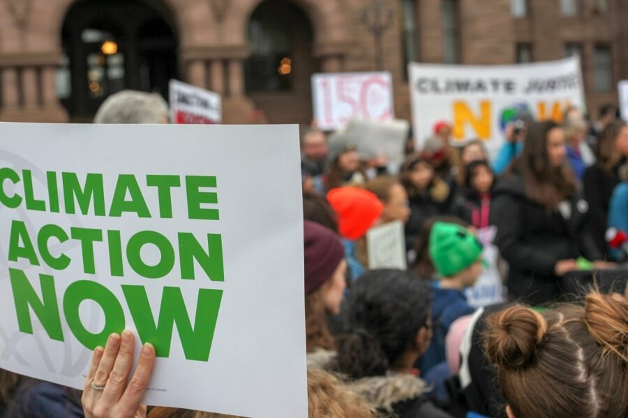 Ein Demo-Teilnehmer bei Fridays for Future hält ein Schild. Aufschrift: "Climate Action now"