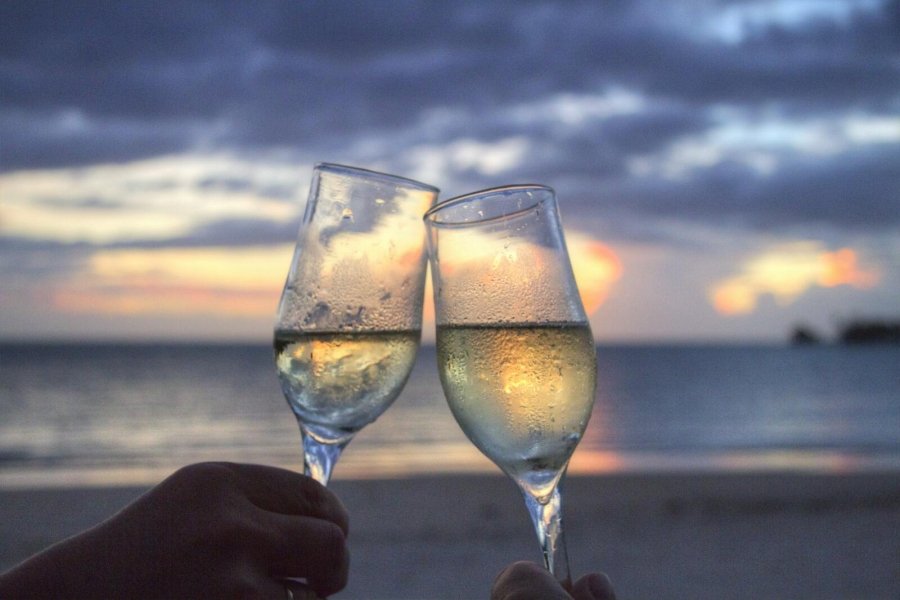 Zwei Personen am Strand mit Weingläsern