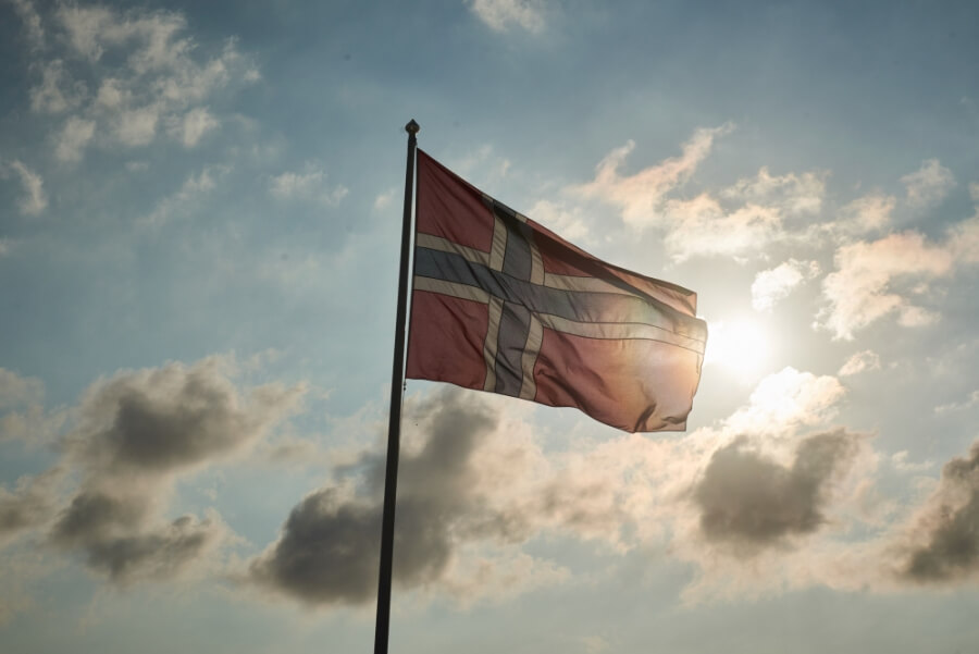Eine norwegische Flagge im Gegenlicht der Sonne.
