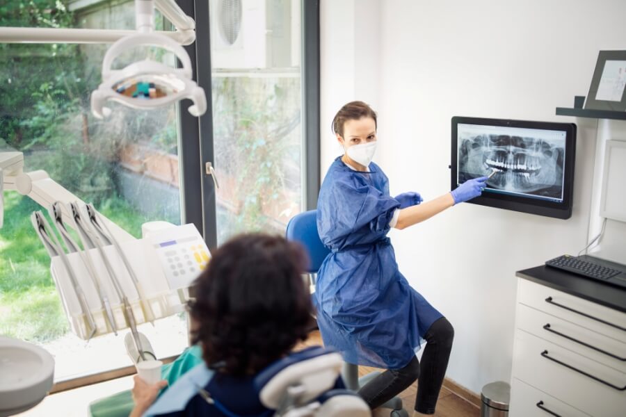 Eine Zahnärztin zeigt einer Patientin Röntgen-Aufnahmen des Gebisses