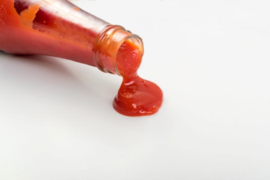 Ketchup läuft aus einer Flasche heraus.