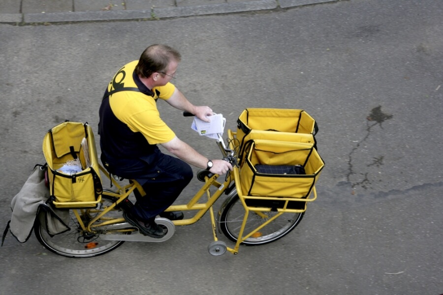 Briefträger der Deutschen Post AG auf einem Fahrrad