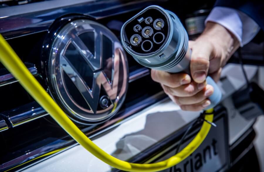 Ein VW-Mitarbeiter steckt bei der Volkswagen-Hauptversammlung ein Ladekabel an einem VW Passat mit Plugin Hybrid Technologie.