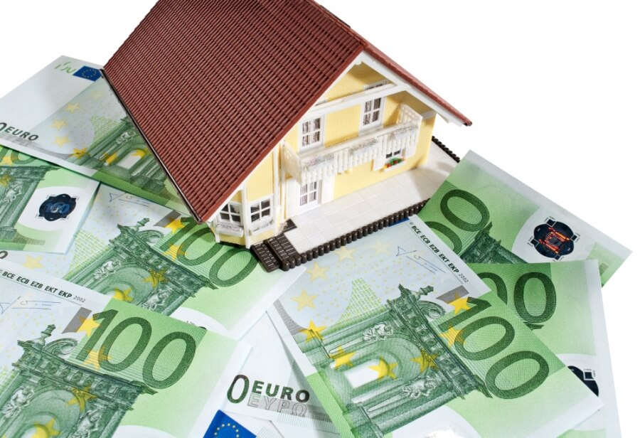 Das Modell eines Hauses steht auf mehreres 100-Euro-Banknoten