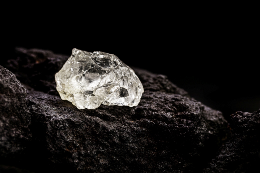 Ungeschliffener Rohdiamant liegt auf einem Stein