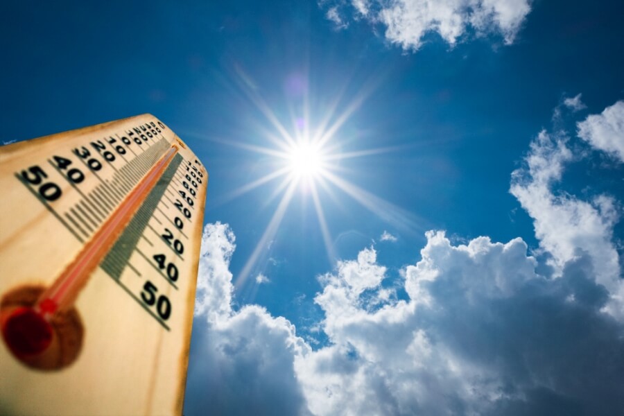 Thermometer mit steigender Temperaturanzeige, am Himmel scheint die Sonne