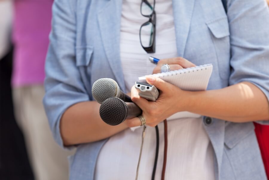 Reporterin mit Mikrophon und Schreibblock