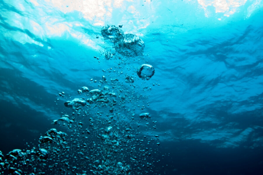 Luftblasen steigen unter Wasser auf
