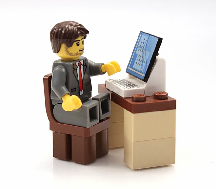 Lego-Figur sitzt an einem Schreibtisch mit Laptop