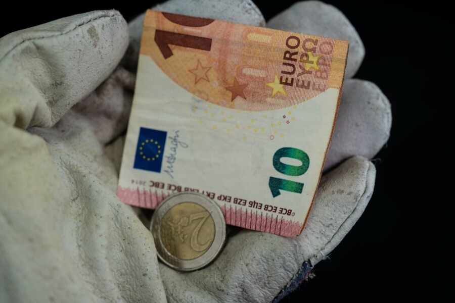 12 Euro liegen auf einem Arbeitshandschuh, Symbolbild Mindestlohn