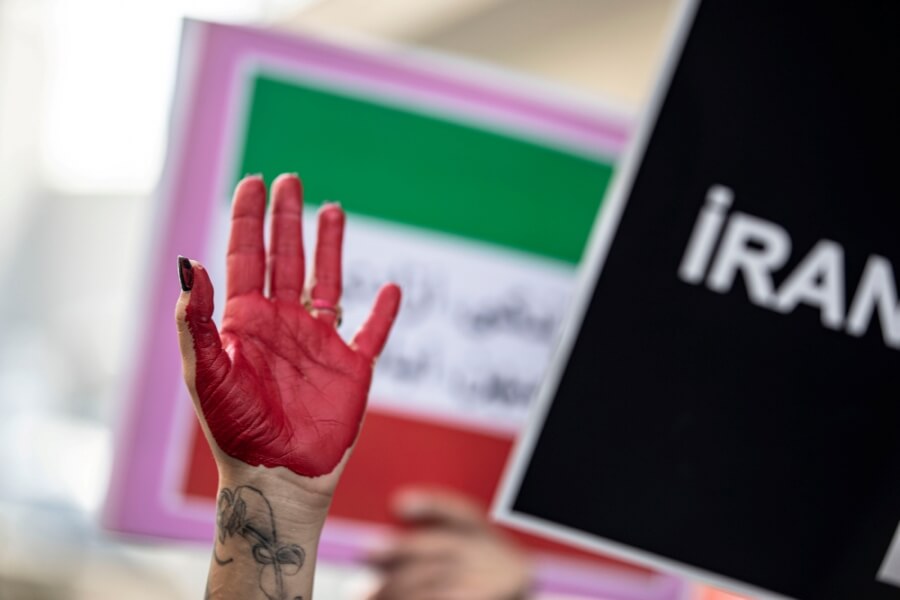 Eine rot angemalte Hand wird während Protesten gegen das Regime im Iran in die Luft gestreckt