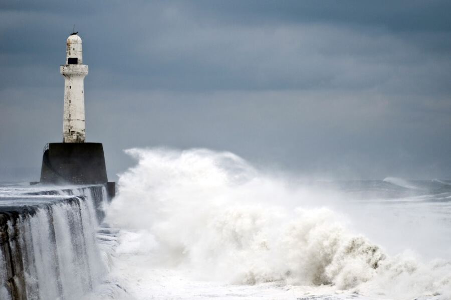 Wellen schlagen an eine Kaimauer im Hafen von Aberdeen