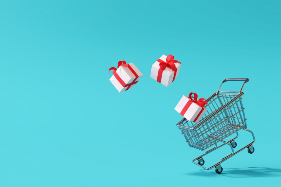 Shopping cart with gift box on blue background