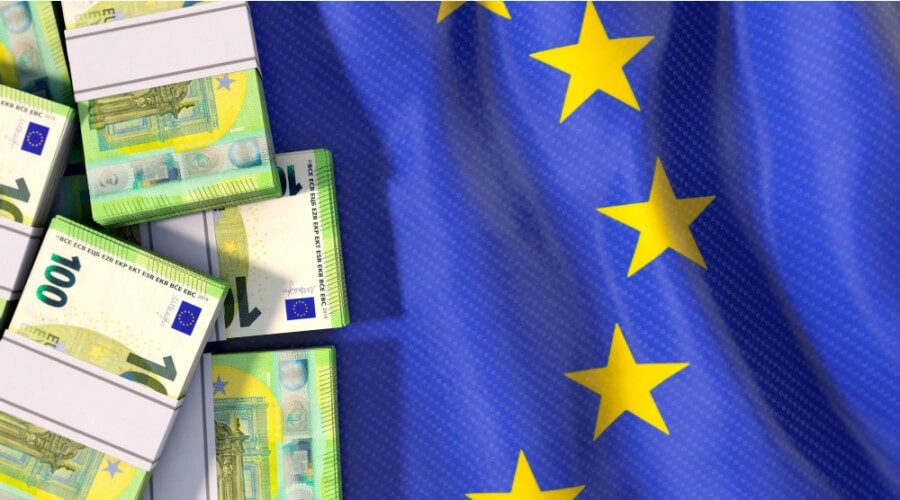 Geldstapel liegen auf einer Flagge der EU