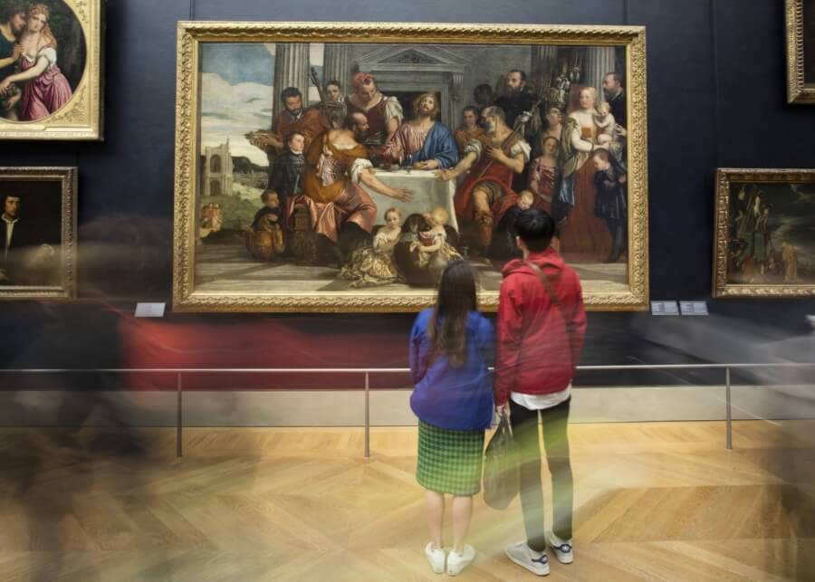 Besucher des Louvre betrachten ein Bild von Emmaus von Veronese 