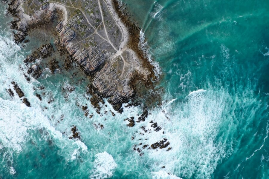 Eine Klippe wird vom Meer umspült. Foto aufgenommen von einer Drohne.
