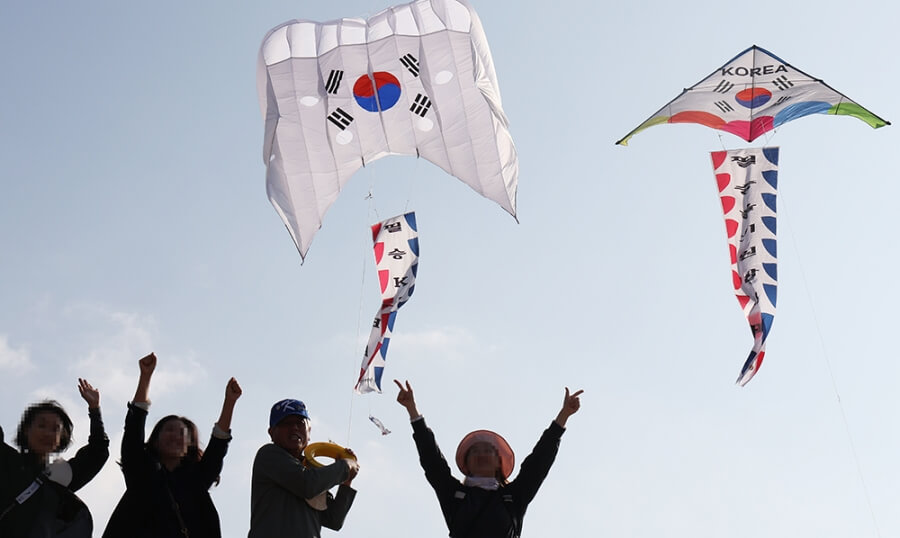 Menschen in Südkorea lassen Drachen mit dem Aufdruck der südkoreanischen Flagge steigen