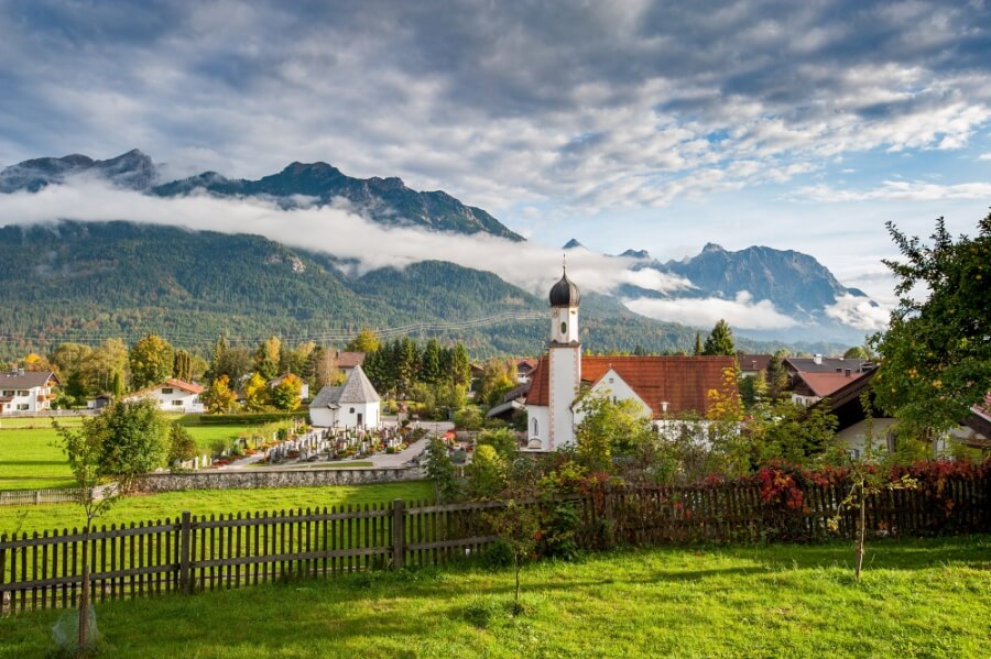 Wallgau, Oberbayern, Dorf mit Kirche und Alpen im Morgennebel