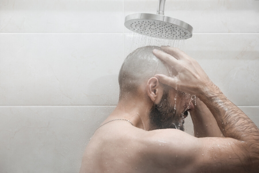 Ein Mann wäscht sich unter der Dusche
