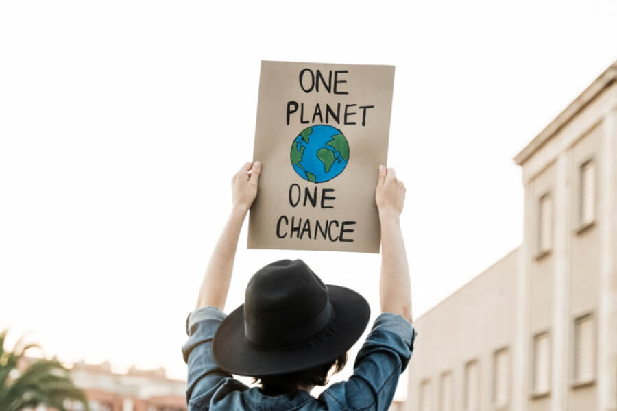 Demonstrant auf einem Klimaprotest hält ein Schild in die Luft