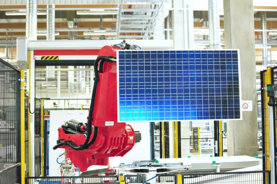 Industrieroboter in einer Fabrik hält ein Solar-Panel