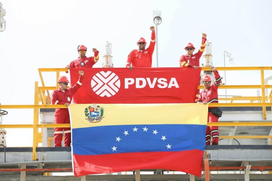 Arbeiter der PDVSA halten eine venezolanische Flagge empor