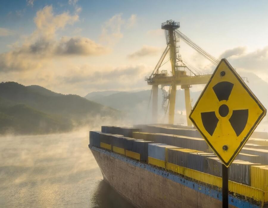 Strahlenwarnzeichen im Vordergrund, im Hintergrund ein Containerschiff