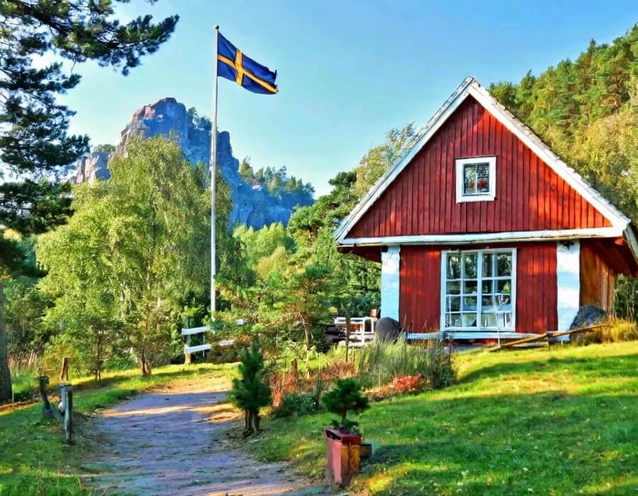 Haus in Schweden, erkennbar an der schwedischen Flagge im Garten.