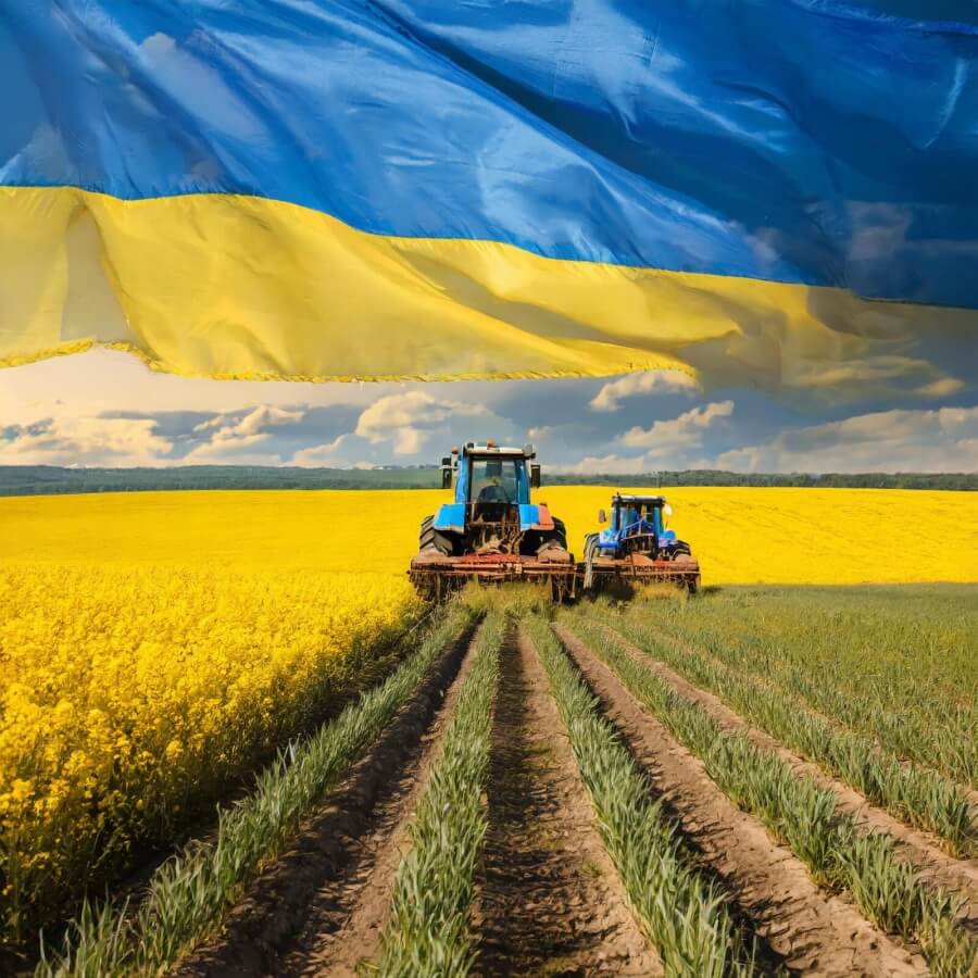 Traktoren auf einem Feld und Ukraineflagge im Vordergrund des Bildes